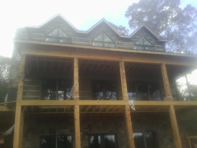 Dormers and porch framing on a large log home under construction — Roof Coating work by our crew in Tallassee