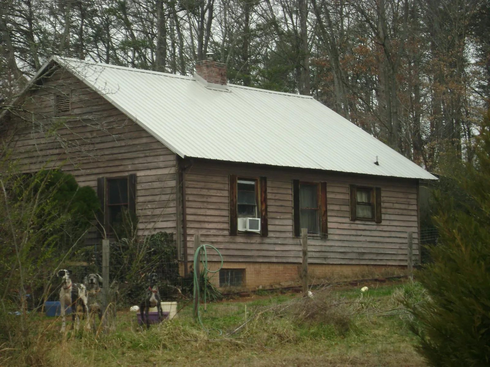 White metal roof on an old wood sided farmhouse, from a Metal Roof Installation job in Tallassee